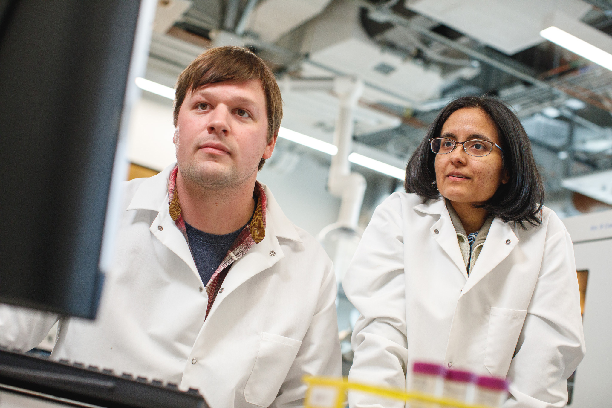 Two researchers in a lab looking at experiment results on a computer screen